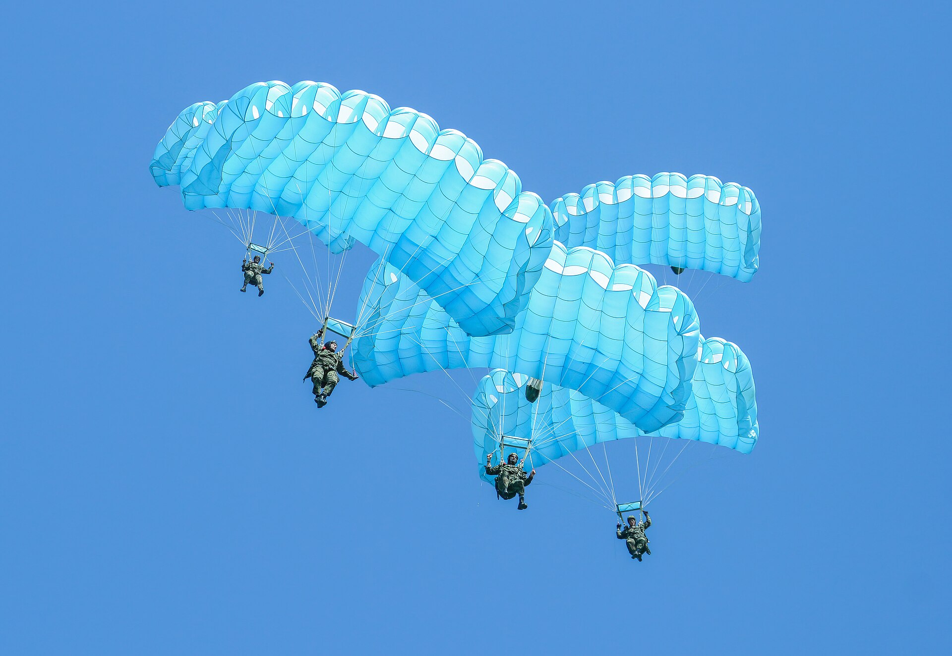 Parachute canopies under a blue sky