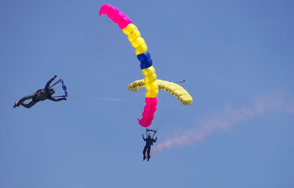 Skydiver in freefall next to an open parachute